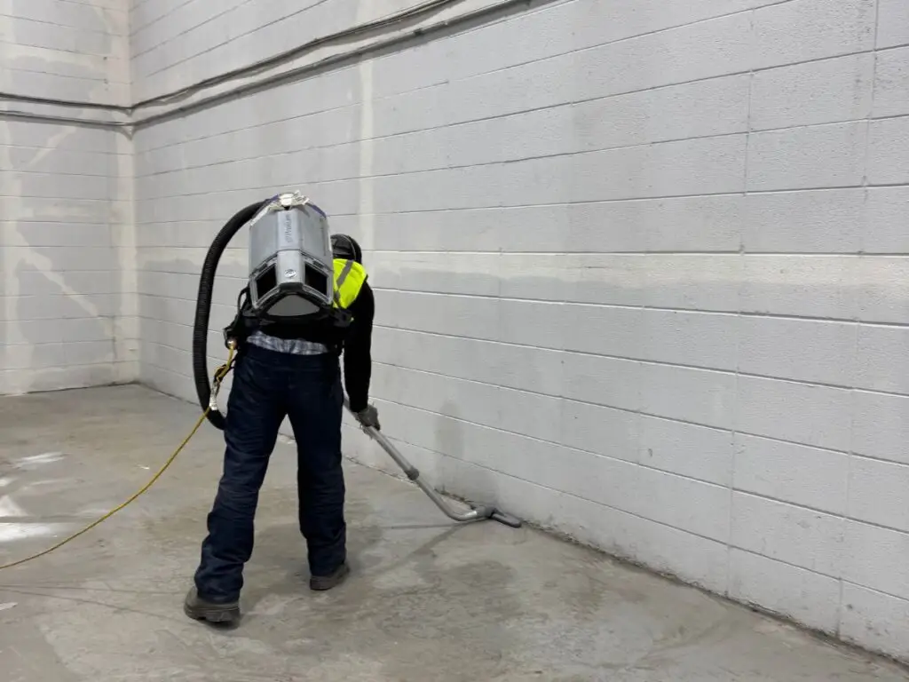 Cleaning sawdust and debris from a film set construction workshop in Calgary.